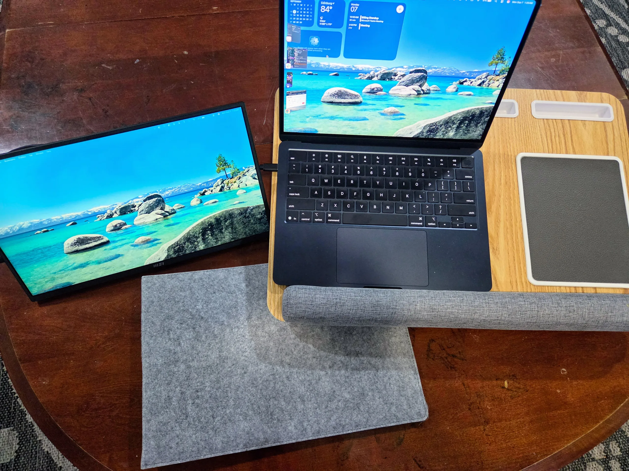 Overhead view of the MSI Portable PRO MP165 E6 set up as a second screen next to a MacBook
